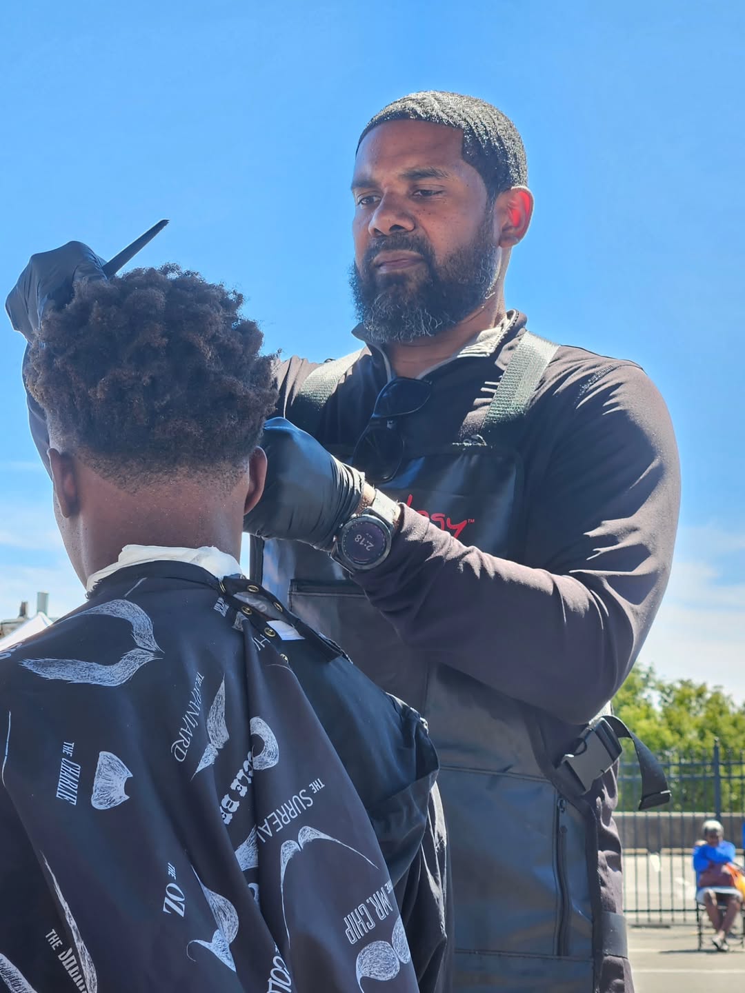 Kevin cutting a client's hair at Knockout Cuts by Kevin